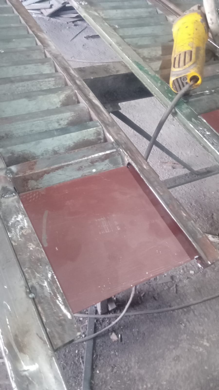 Herrero reparando perfiles de celosía en banco de trabajo